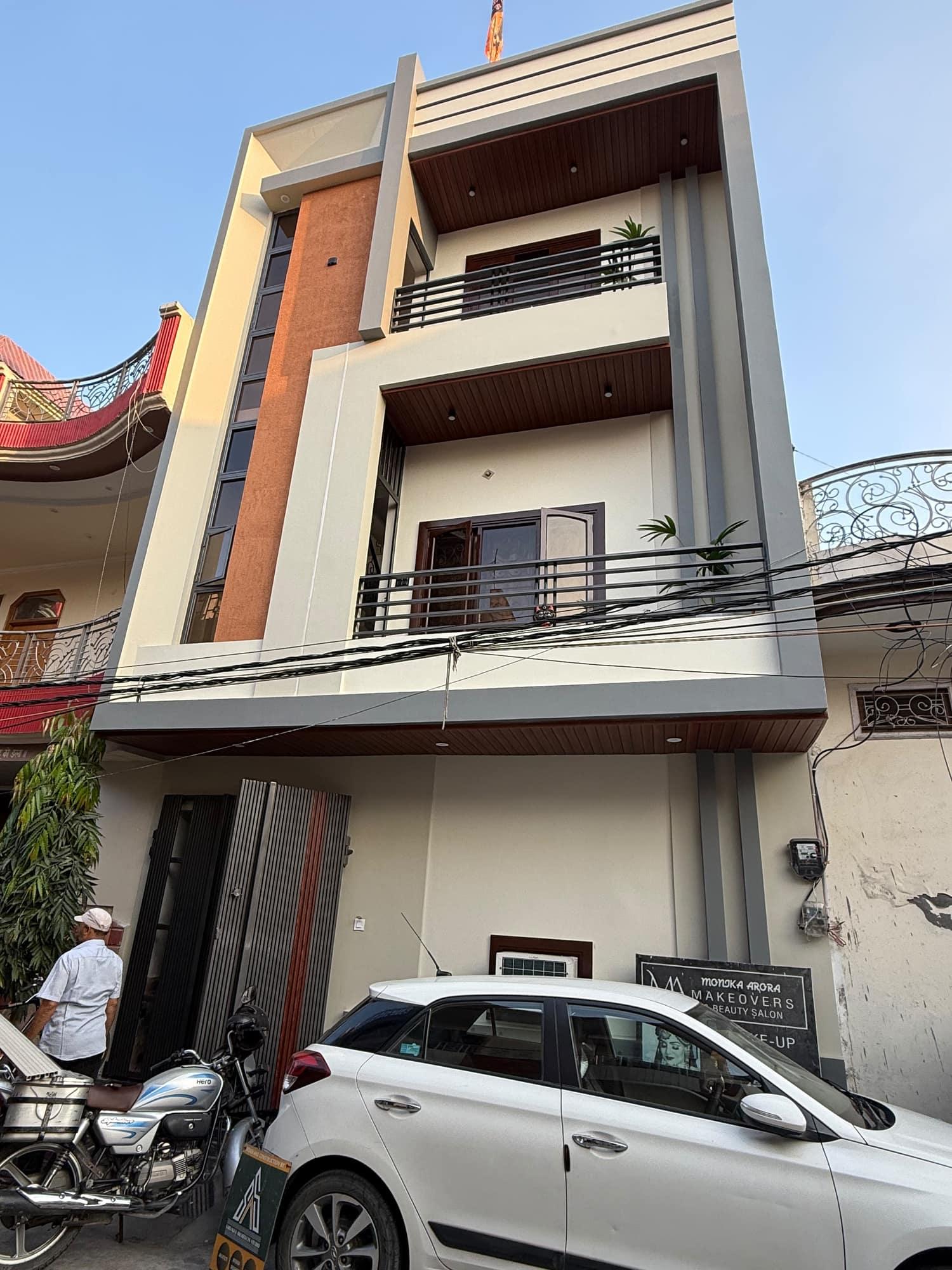Street photograph of a built narrow-plot house with a glazed vertical stair strip and stacked balconies
